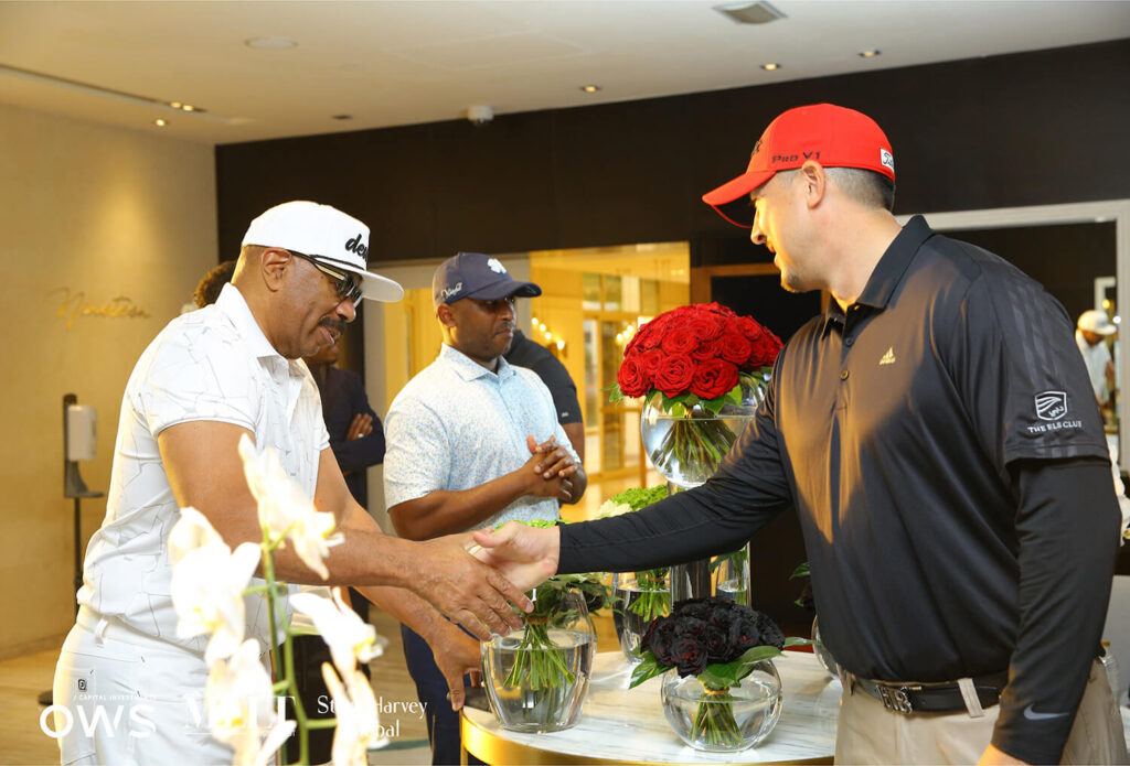 Steve Harvey shaking hands with participants
