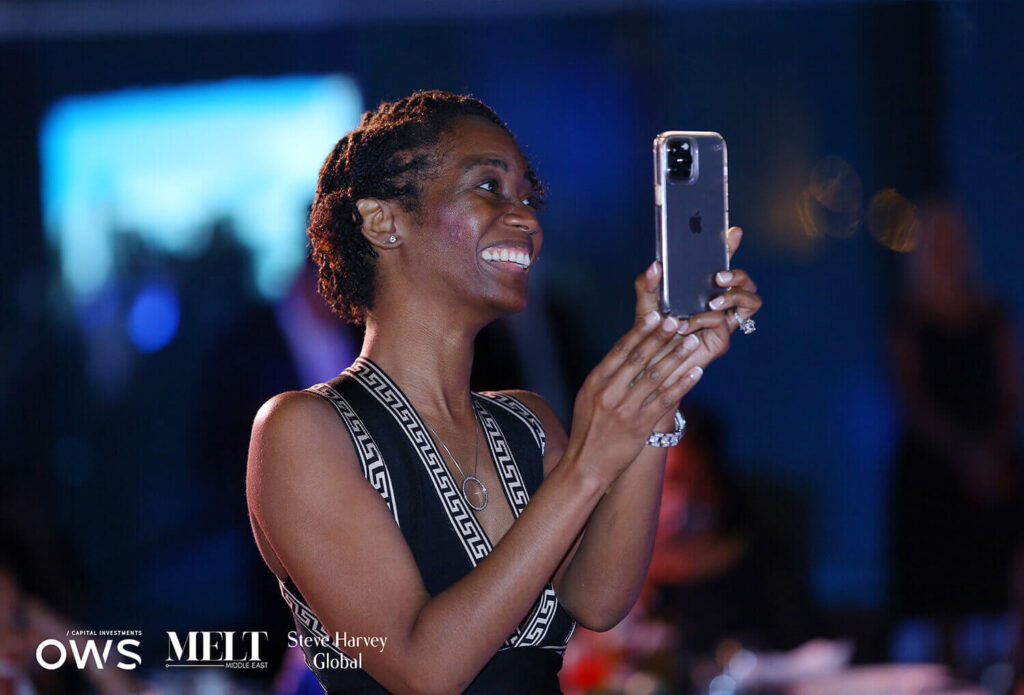 Guest with smart phone smiling to record the moment