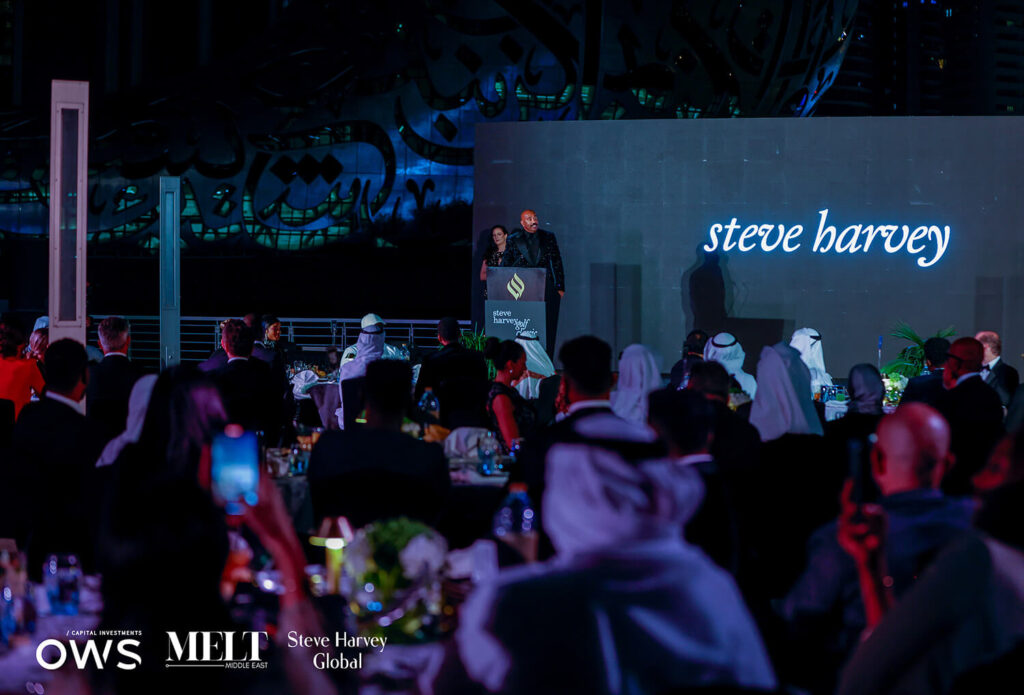 Steve at the podium with the participants at their dinner tables in the shot