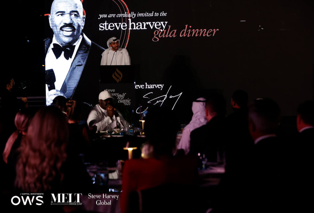 A speaker at the podium for the dinner with guests shown at their tables