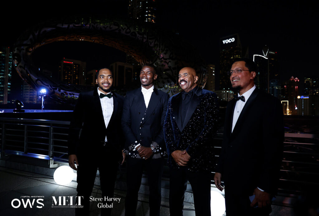 Guests posing for a picture with Steve Harvey